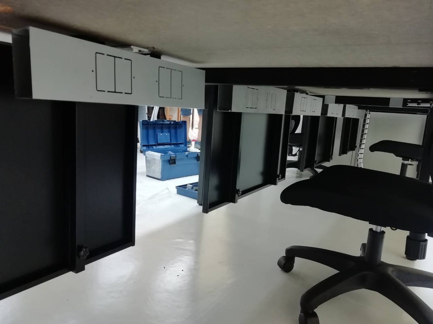 黑腳工作桌桌下一支銀色鋁製走線槽,側面有插座開孔